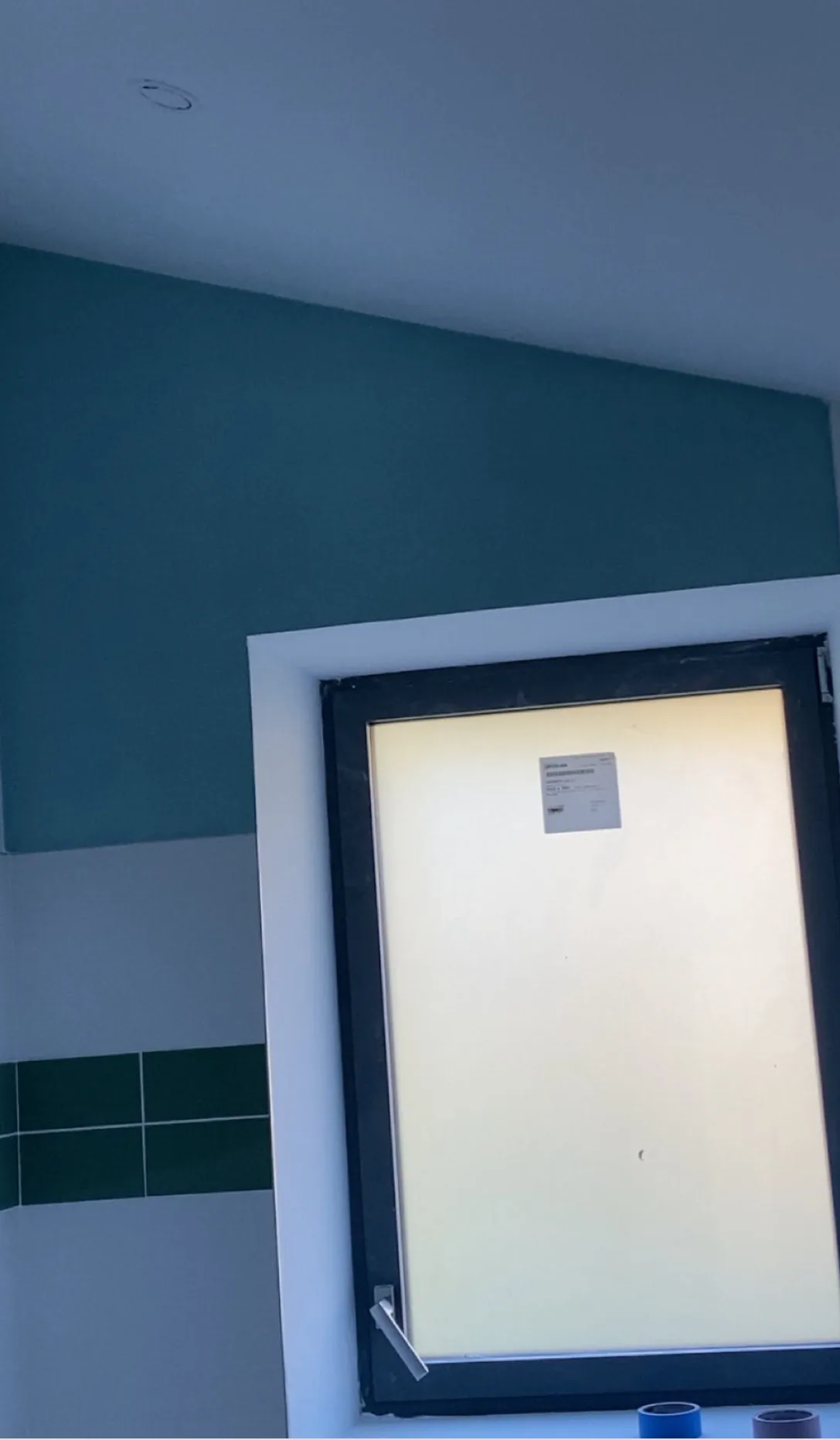 Salle d’eau avec mur bleu-vert et encadrement blanc